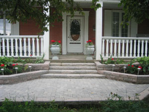 Cotie. Front elevation shows how an old deck can be enhanced using interlocking stone